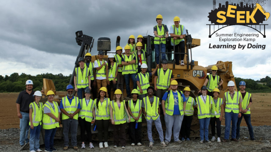 Group of students on bull dozer with logo